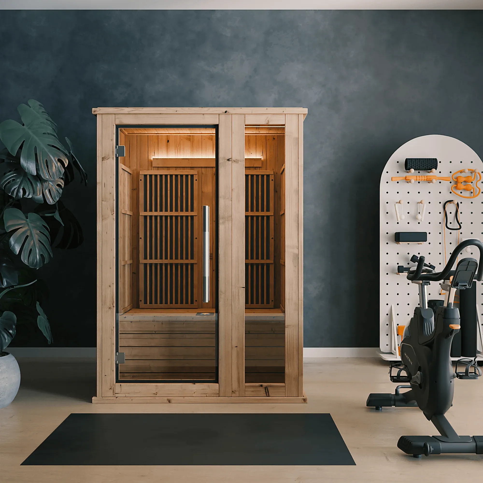 An infrared sauna cabin beside exercise equipment in a fitness space